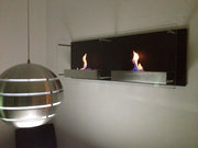 Double Nevada bioethanol wall-mounted fireplace with lit flames, mounted on a wall beside a spherical pendant lamp in a dimly lit room